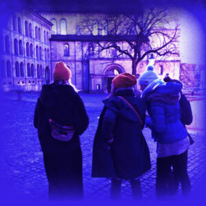 Das Bild zeigt eine Gruppe junger Leute, welche in Winterkleidung auf ein Handy schauen.